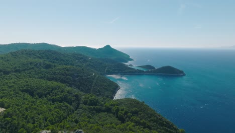 Flyover-shot-dollying-along-the-coastline-of-Lastovo-Island-in-Croatia-on-a-bright-morning