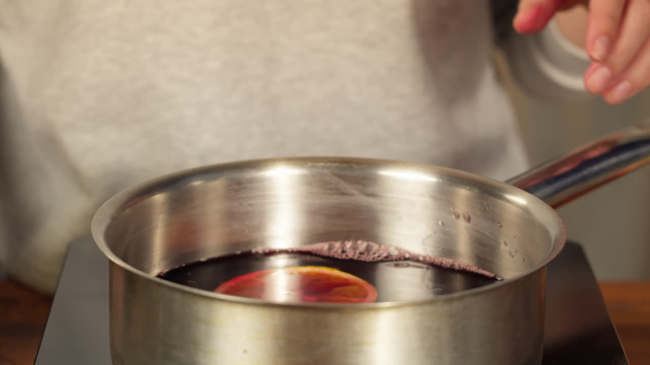 Preparing Mulled Red Wine with Orange Slices and Spices