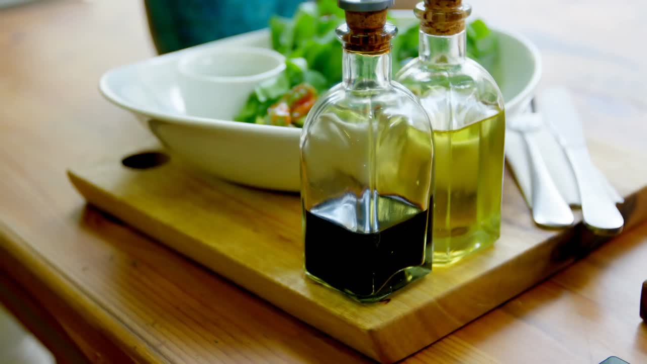 Bowl of salad and olive oil bottles on the table in restaurant 4k
