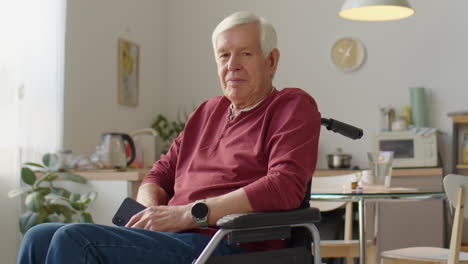 portrait of elderly man in wheelchair at home