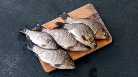 pescado de cocina. carpas pequeñas frescas en la mesa en una tabla de madera de primer plano.