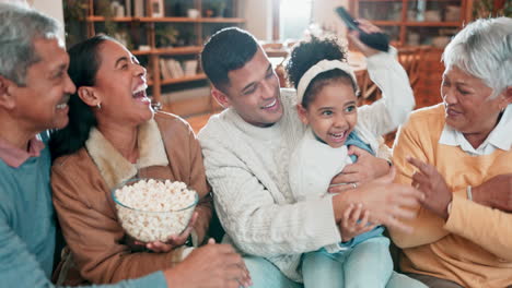 family, popcorn and watching a movie on a sofa