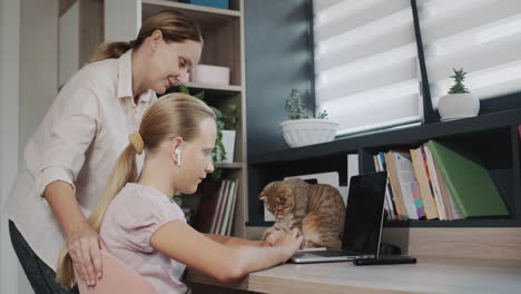 mom helps a teenage girl do her homework. education at home concept