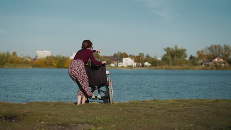 aunt spends time with niece in wheelchair on river bank