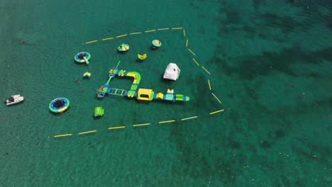 inflatable water park floating in the blue sea. - aerial shot