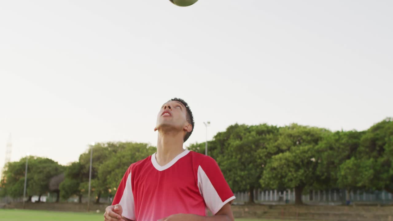 video de un jugador de fútbol biracial en el campo con la pelota