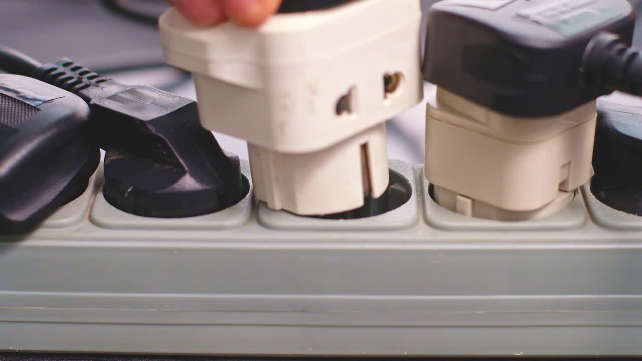 Man tries to put a large block in the only free outlet of power strip. Daily life problems. Close up