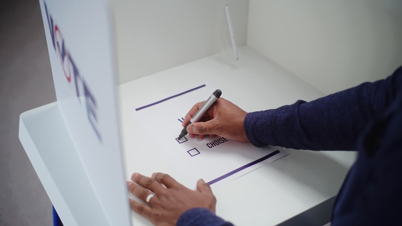 African American Man Thinks which Presidential Candidate to Vote for Close up of African American Man Thinking and Choosing which Presidential Candidate to Vote for in Voting Booth at Polling Station us Citizen during National Election Day in United States of America