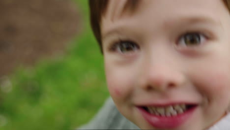 A-young-boy-is-playing-in-the-garden-and-his-mother-is-taking-his-video-camera