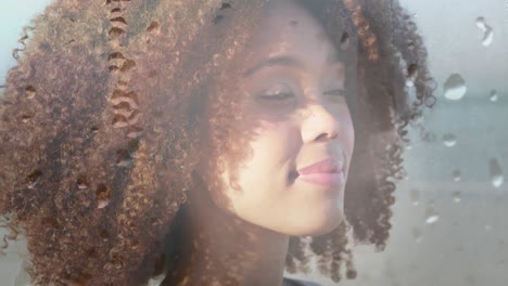 Animation-of-smiling-african-american-woman-at-beach-over-droplets