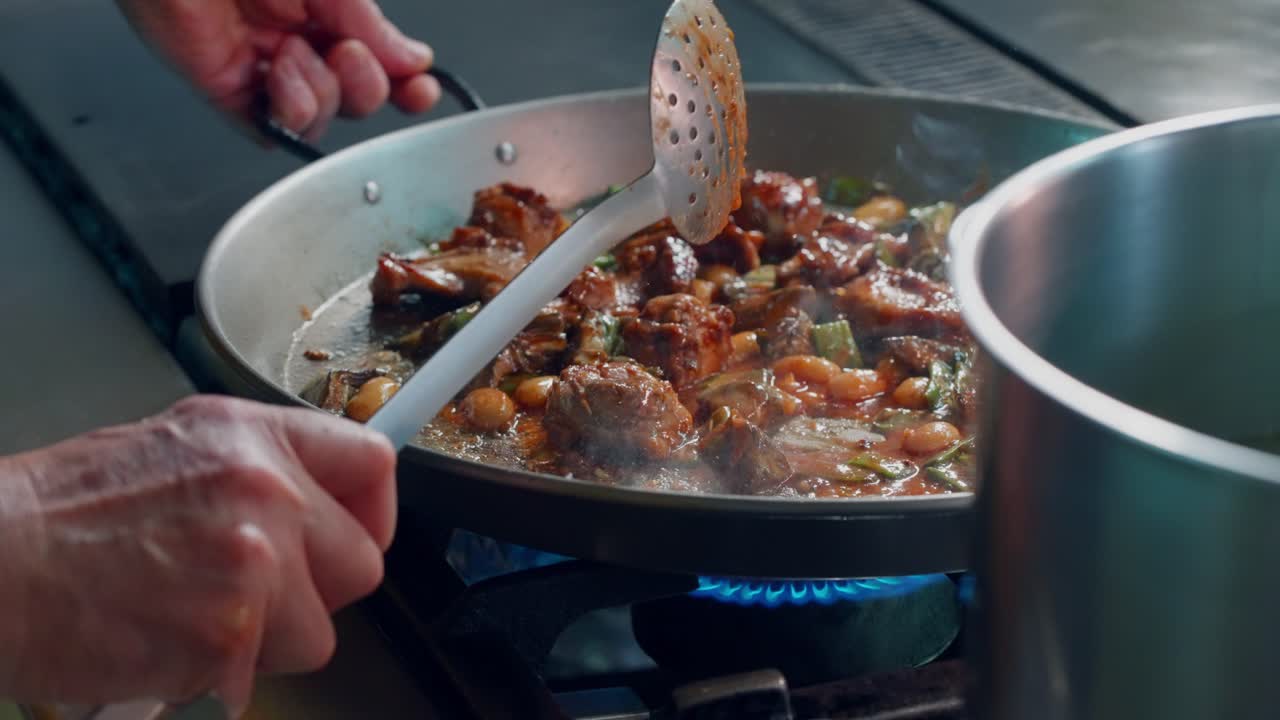 Kock rör om ingredienser för att göra spansk paella