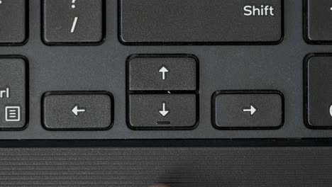 top view finger pressing arrow keyboard buttons