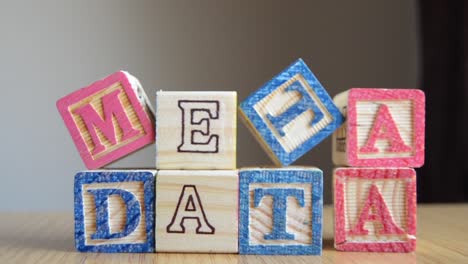 metadata - educational toys, cubes with letters, placed together to make word metadata