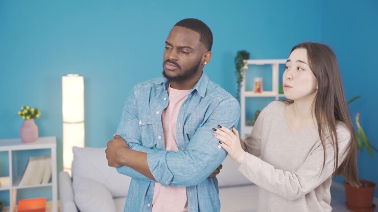 Asian woman comforts her african husband about his problem.