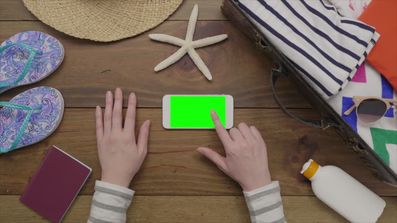 imágenes aéreas de una mujer usando un teléfono inteligente por suministros de playa