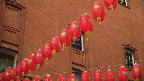 china town celebrates the new chinese year in london, leicester street hanged on strings plenty many of lantern traditional balloons tighten on windows windy weather moving around cloudy weather