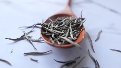 white tea in wooden spoon
