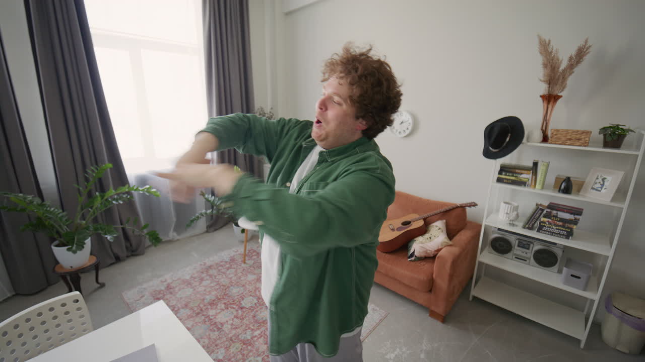 Energetic Man Dancing and Singing as Recording Social Media Video at Home