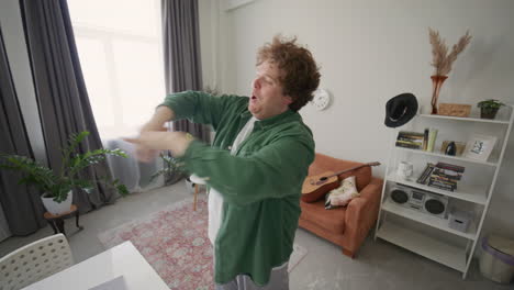 energetic man dancing and singing as recording social media video at home