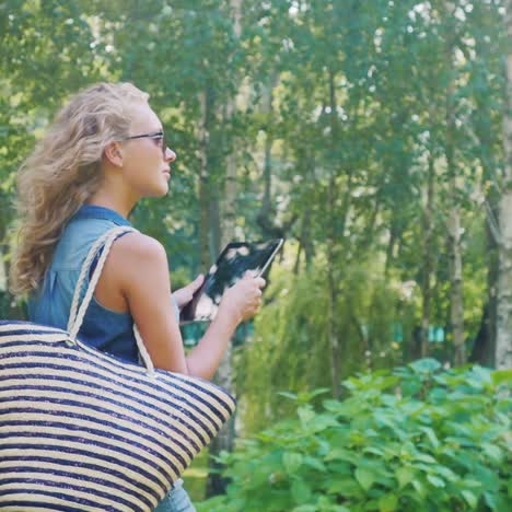 a young attractive woman walks in a well-groomed park on a summer day 1