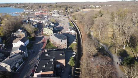 Vista-De-Retroceso-De-Drones-De-áreas-De-Estacionamiento,-Junto-Al-Puerto,-Carreteras-Y-área-Comercial-De-Hingham,-Ma,-Ee.uu.