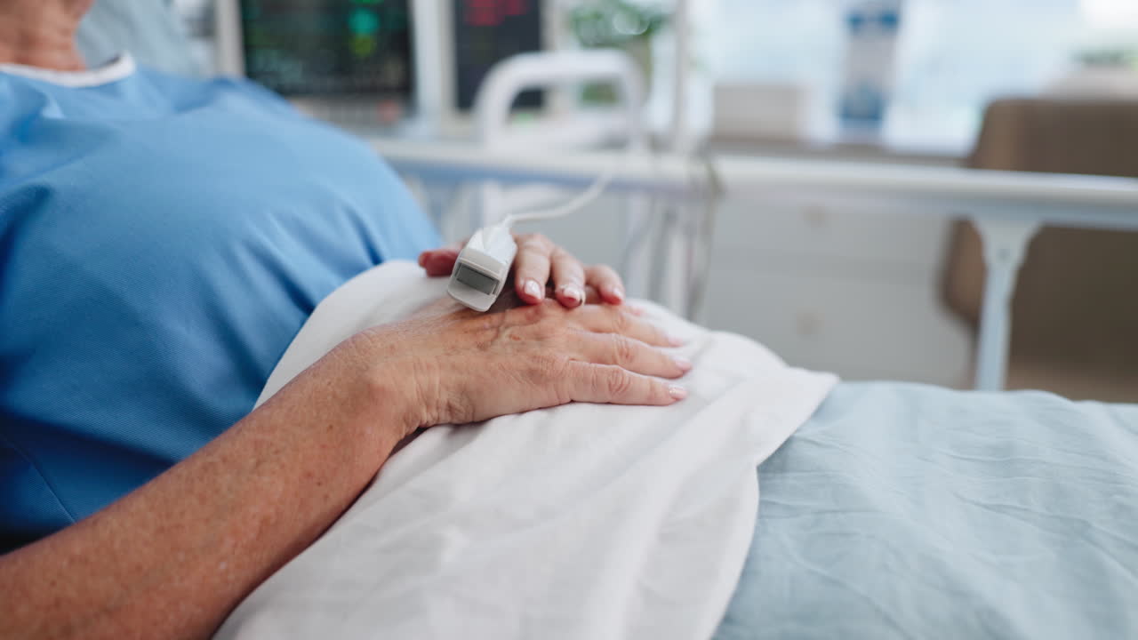 Close-up of Patient's Hand with Pulse Oximeter in Hospital Bed