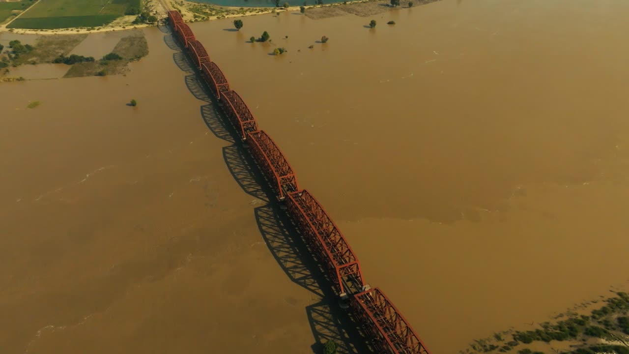 Aerial view showing Sutlej River floodwaters partially submerging land near a railway bridge