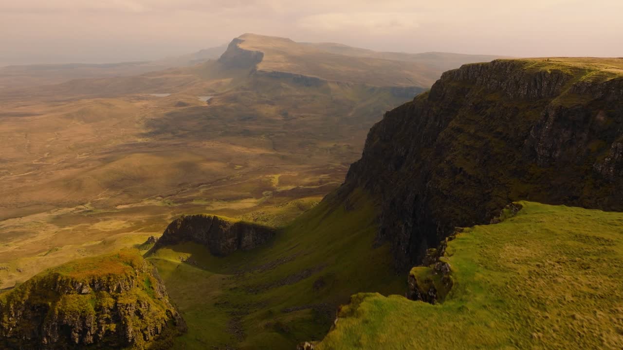 Aerial drone footage of the dramatic mountain landscapes on the Isle of Skye, Scotland. Sweeping panoramic views of majestic peaks, green valleys, and wild nature