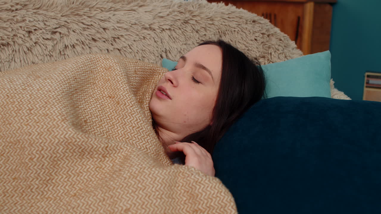 Woman waking up terrified on sofa after nightmare breathing heavily scared stressed disoriented