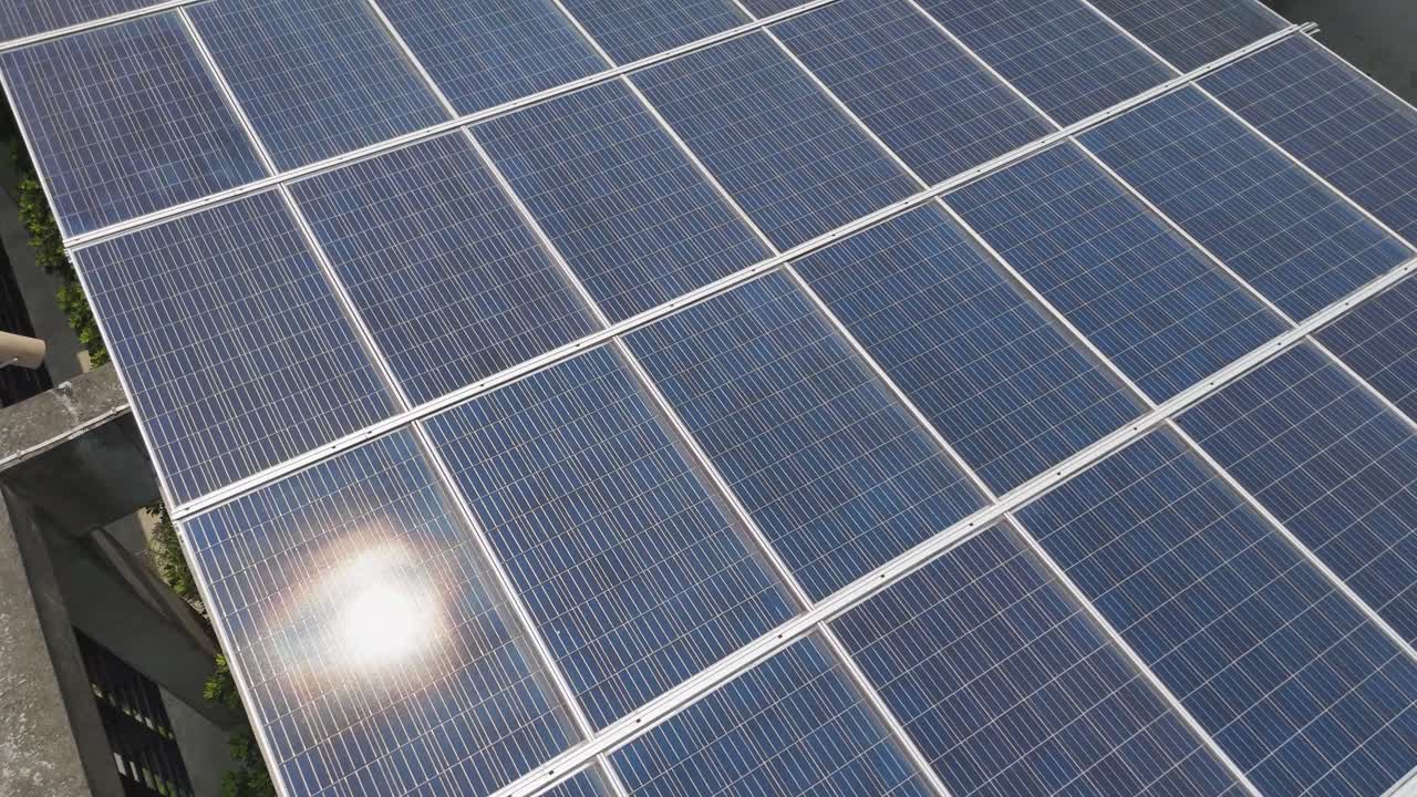 Close-up drone shot of rooftop solar panels in Kuala Lumpur, Malaysia. Sustainable urban energy installation on a modern building, promoting renewable power and green architecture