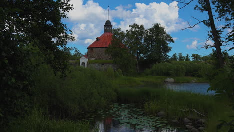 Peaceful-green-foliage-and-calm-water-giving-relief-vibes-near-the-old-fortress-called-Korela-in-Russia