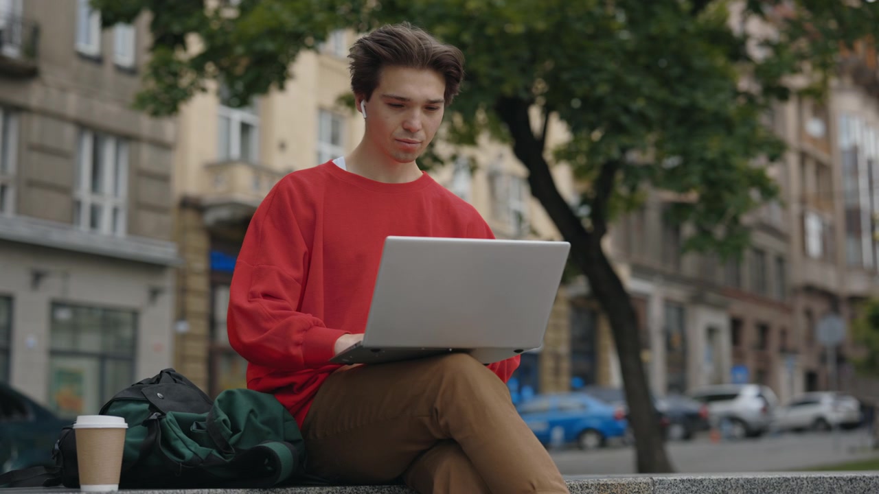 Man using laptop in city