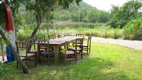 silla de madera vacía y mesa en el jardín