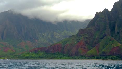 hd 120fps hawaii kauai paseos en bote en el océano de derecha a izquierda de las montañas y el verde valle nublado con spray de barco en primer plano