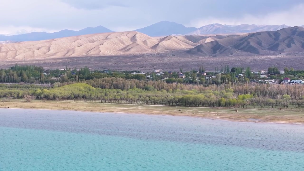 Altın rengi ışıkla kaplı dağ sırasına sahip Issık Göl'ün güney kıyısı. Kırgızistan manzarası.