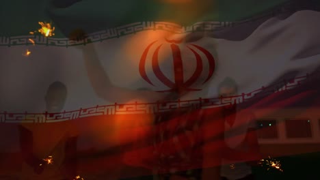 animation of waving flag of iran over group of friends having fun on the beach