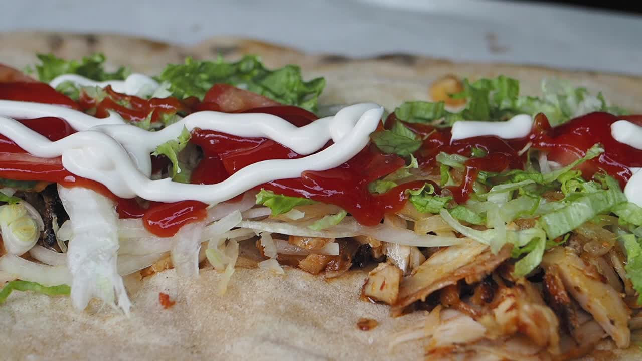 Aggiungere maionese a un delizioso wrap di kebab di pollo.