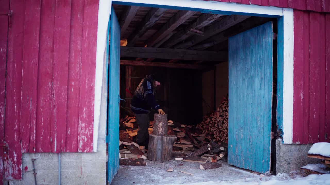 un hombre está usando un hacha para cortar leña en indre fosen, condado de trondelag, noruega - toma estática
