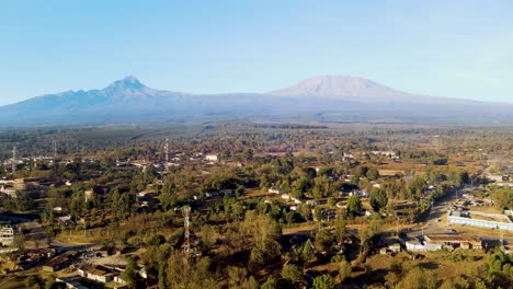 Sonnenaufgang-–-Kenia-Landschaft-Mit-Einem-Dorf,-Kilimandscharo-Und-Amboseli-Nationalpark-–-Verfolgung,-Drohnen-Luftaufnahme