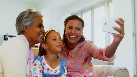 happy family taking a selfie with mobile phone in living room 4k