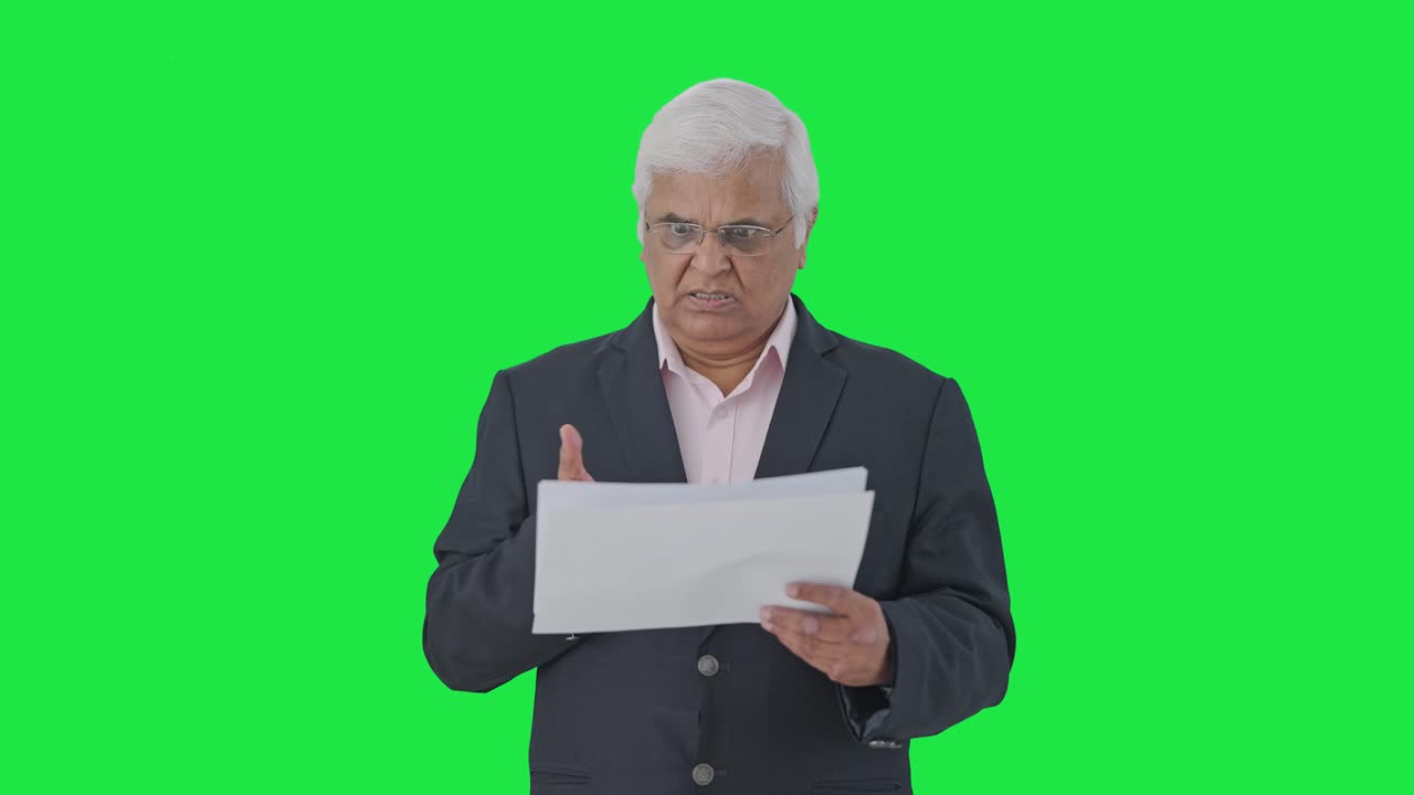 el gerente senior indio enojado leyendo informes pantalla verde