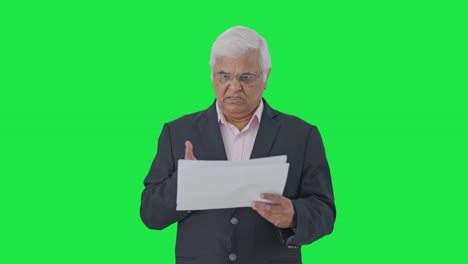 el gerente senior indio enojado leyendo informes pantalla verde