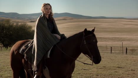 woman riding a horse in a wide open rural landscape