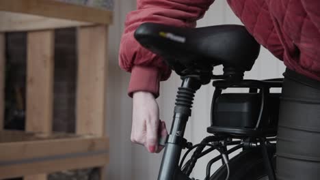 Lady-adjusting-the-height-of-her-new-electric-bicycle-before-taking-it-out-for-the-first-ride