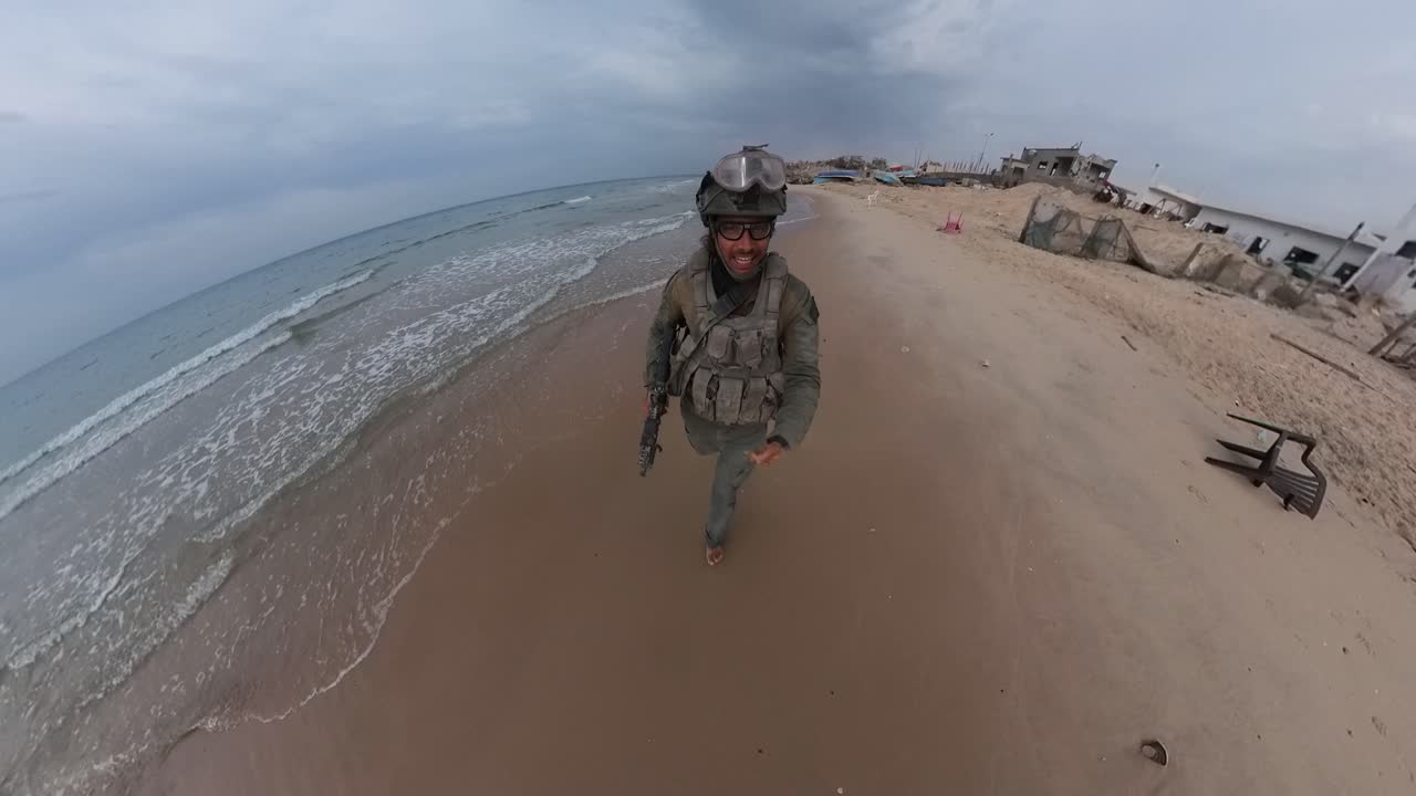 un soldado israelí en gaza corriendo por la playa en su uniforme con los pies descalzos