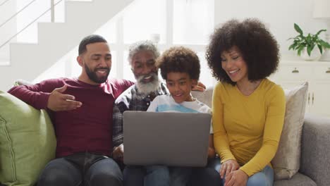 Familia-Multigeneracional-Usando-Una-Computadora-Portátil-En-El-Sofá-En-Casa