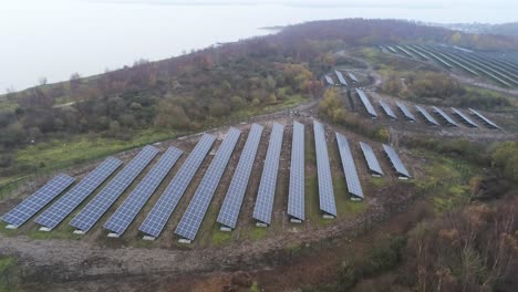 Matriz-De-Paneles-Solares-Filas-Vista-Aérea-Brumoso-Otoño-Bosque-Campo-Lento-Inclinación-Hacia-Arriba-Descender