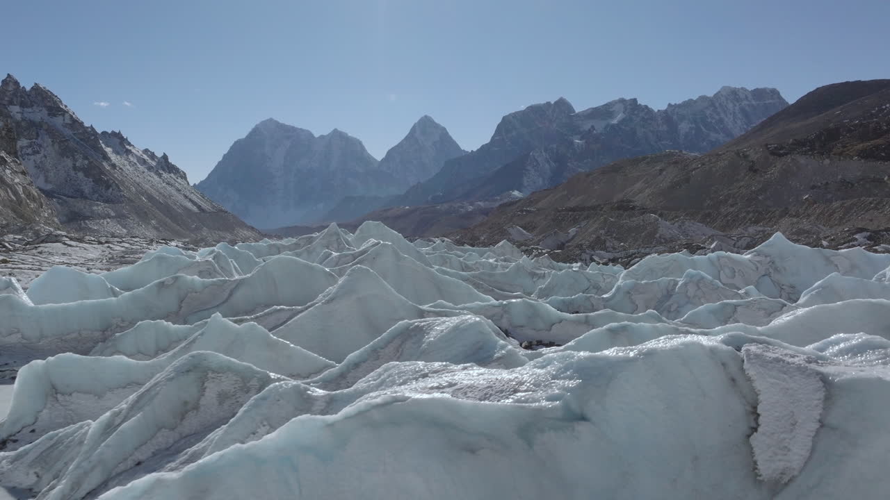Svävande flygvy som rör sig mot istorn under oländiga berg i Everestregionen Nepal, visande frusna formationer i det himalayanska landskapet.