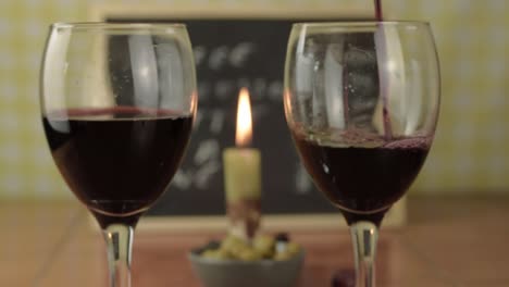 Gießen-Sie-Rotwein-In-Ein-Glas-In-Der-Bar-Mit-Mittlerer-Kerze