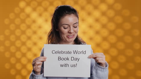 retrato de una mujer feliz sosteniendo un cartel con el mensaje del día mundial del libro